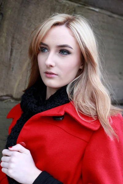 Schöne junge Frau mit blonden Haaren trägt rote Jacke — Stockfoto