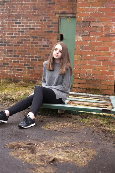 Красивая молодая девушка-подросток сидит на старых дверях снаружи — стоковое фото