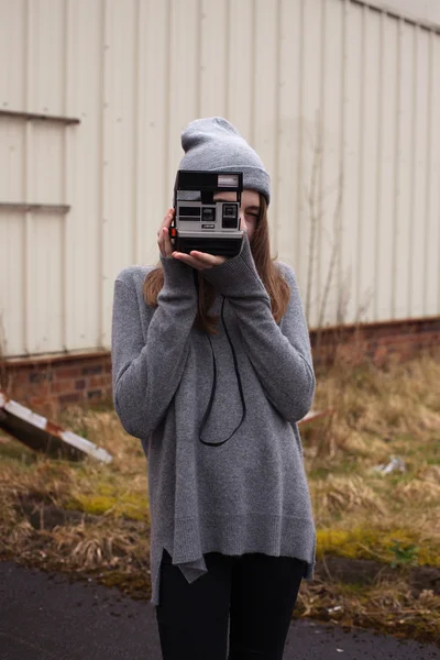 Adolescente parler de photos avec un appareil photo polaroid — Photo