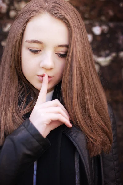 Tienermeisje met haar vinger aan haar lippen voor stilte — Stockfoto