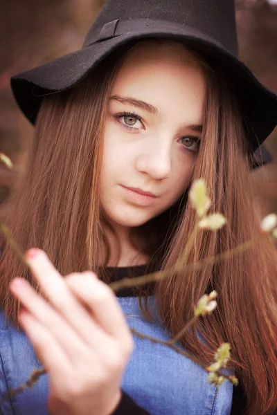 Bela adolescente segurando um ramo em flor — Fotografia de Stock