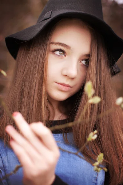 Schöner Teenager mit einem Zweig in Blüte — Stockfoto