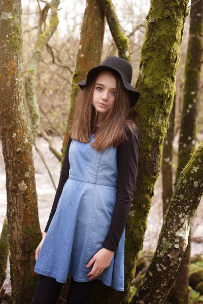 Hübsche Teenager-Mädchen lehnt an einem Baum mit einem Fluss in der b — Stockfoto