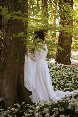 Bir genç kadın geri uzun beyaz bir elbise 