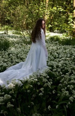 Ormanlık bir ortamda arıyorum uzun beyaz bir elbise giyen güzel kadın