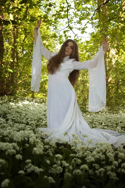 Bir ormanda dans uzun beyaz bir elbise giyen güzel kadın — Stok fotoğraf