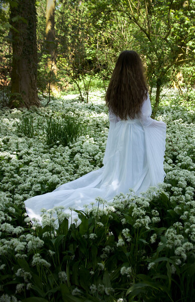 Back of a young woman wearing a long white dress