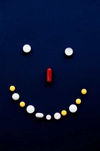 Auswahl von Tabletten in Form eines Smileys auf schwarzem Hintergrund — Stockfoto