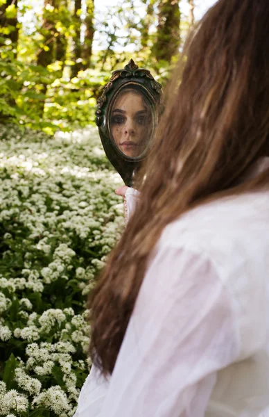 Belle fille regardant dans un miroir — Photo