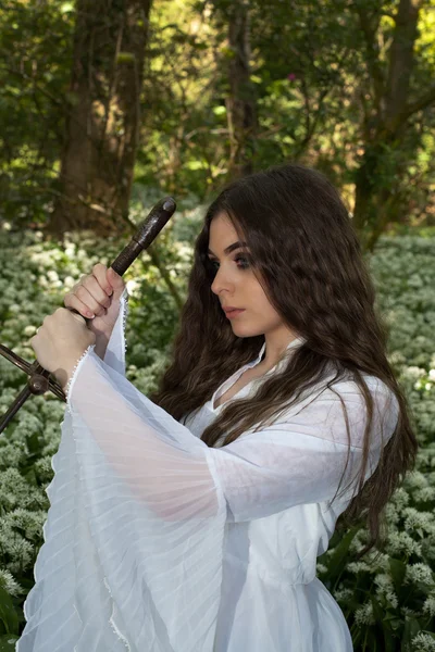 Hermosa joven en un bosque sosteniendo una espada —  Fotos de Stock