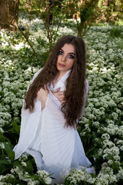 Krásná mladá žena v lese s rukama zkříženýma na prsou proti — Stock fotografie