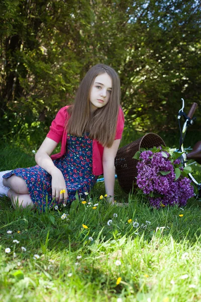 Piękne nastoletnie dziewczyny, siedzący w polu z rowerem — Zdjęcie stockowe