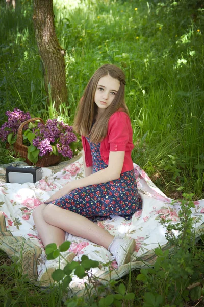 Krásné dospívající dívka seděla na dece v lese — Stock fotografie