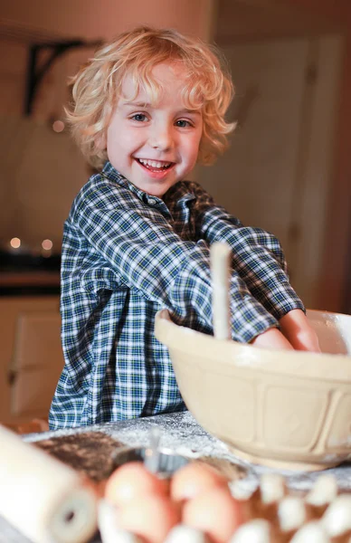 Kleine jongen mengen bloem in een kom — Stockfoto