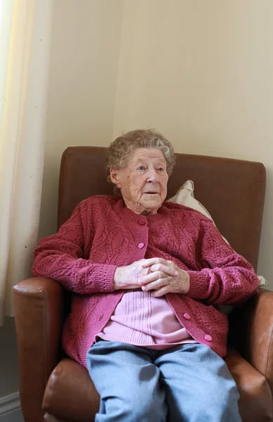 Stara kobieta siedzi — Zdjęcie stockowe