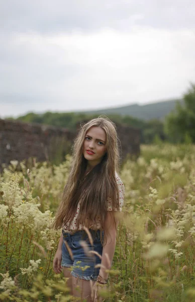 Adolescente de pie en un campo de flores —  Fotos de Stock
