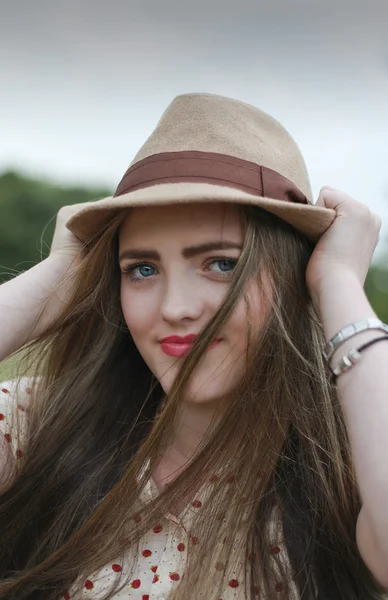 Beautiful teenage girl pulling on her hat — Stock Photo, Image