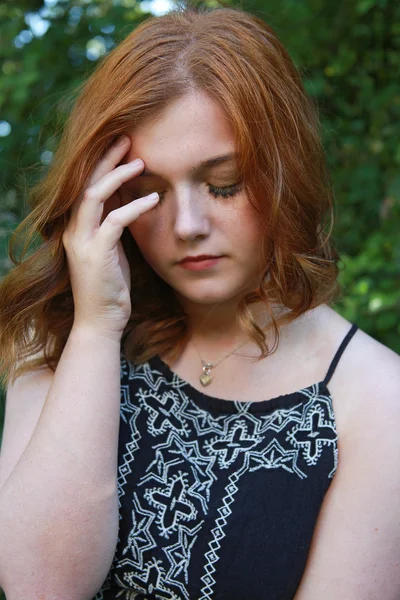 Beautiful young woman holding her head in her hands — Stock Photo, Image