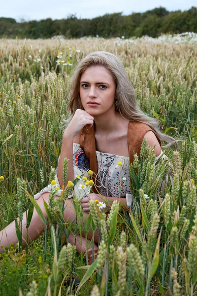 Belle fille assise dans un champ de blé — Photo