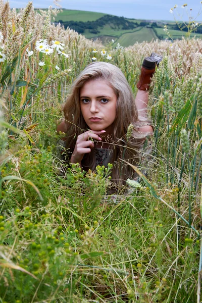 Hermosa adolescente acostada en un campo — Foto de Stock