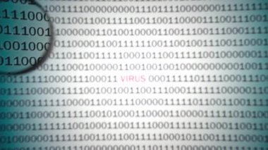 Kırmızı etiket virüslü ikili kod büyüteçle görüntülenir.