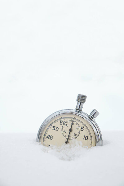 Fallen in the snow, in winter, stopwatch on a white background