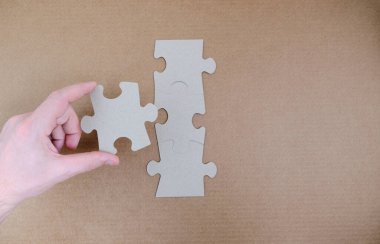 Adamın eli yapbozun kayıp parçasını takıyor.