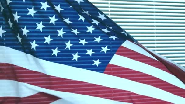 Αμερικανική Σημαία Κυματίζει Στον Άνεμο Φόντο Ένα Παράθυρο Καλυμμένο Περσίδες — Αρχείο Βίντεο