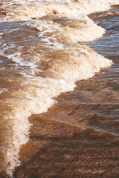 Stream of dirty meltwater on sunny spring day