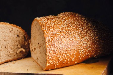 Two halves of sliced bread sprinkled with sesame seeds