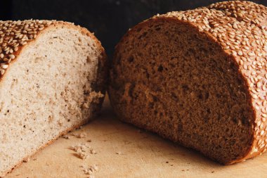 Two halves of sliced bread sprinkled with sesame seeds