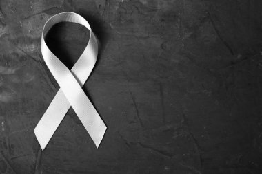 White ribbon on dark concrete background is symbol of protection of traditional family, problem of protecting women from violence clipart