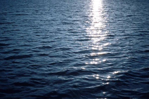 Achtergrond Blauwe Uitgestrektheid Van Oceaanwater Bij Zonsondergang Met Weerkaatste Zonnestralen — Stockfoto