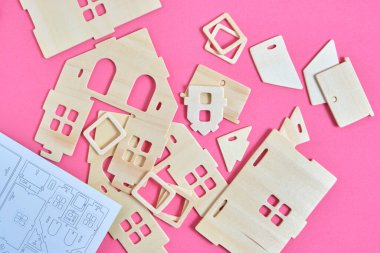 Ayrıntılar ve talimatlar, pembe arka planda prefabrik ahşap yetimhanenin yapımcısı.