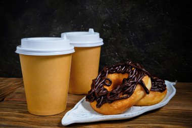 Çikolatalı çörekler ve koyu bir arka planda kahve.