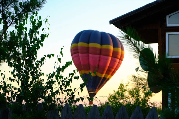 Balão Multicolorido Decolando Contra Árvores Fundo Casas Balão Pôr Sol — Fotografia de Stock