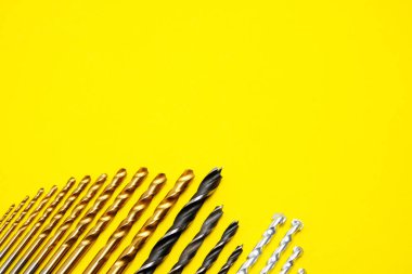 Set of drills for wood, metal and concrete on a yellow background