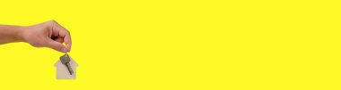 Banner, sarı arka planda anahtarlığı olan ev anahtarları. Bir teklif ve hediye.