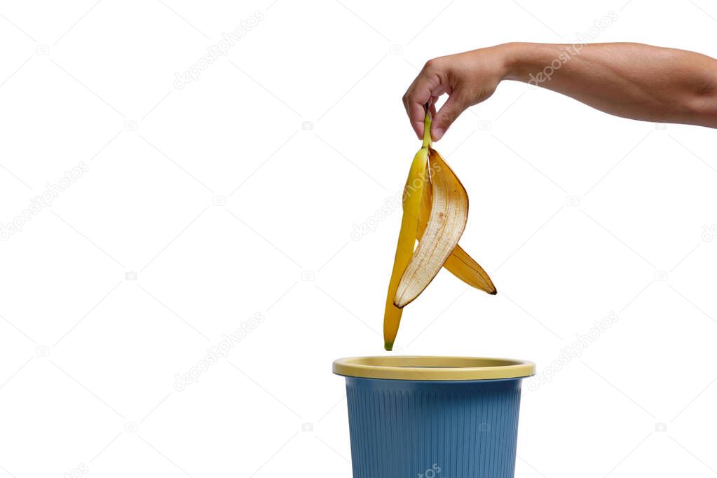 In a man hand, banana peel is thrown into trash.Food waste