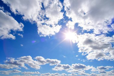 Parlak, yaz, bunaltıcı güneş arka planda mavi gökyüzü ve beyaz bulutlar