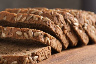Tahtada ayçiçeği tohumlu dilimlenmiş çavdar ekmeği, yakın plan.