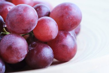 Olgun sulu kırmızı üzümlere yakın dokuları ve doğal çiçekleri gösteren