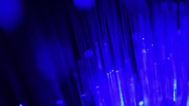 Soyut mavi ve yeşil bokeh ışığı yumuşak fiber optik ışıltıyla sızar.