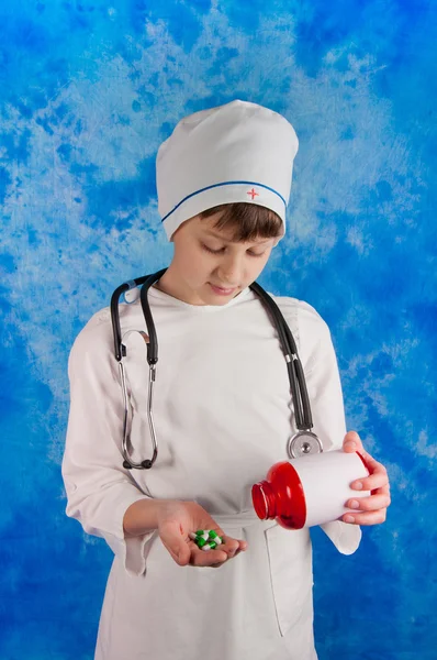 Junge hält Flasche und schaut auf Tabletten — Stockfoto