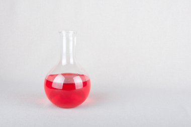 İçinde laboratuvar şişesi beyaz üzerine kırmızı sıvı