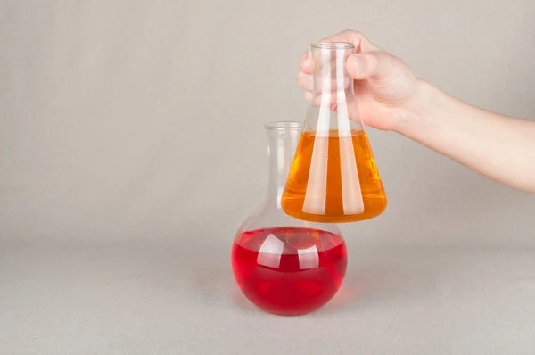 Dos productos de vidrio de laboratorio con líquido en la mano — Foto de Stock