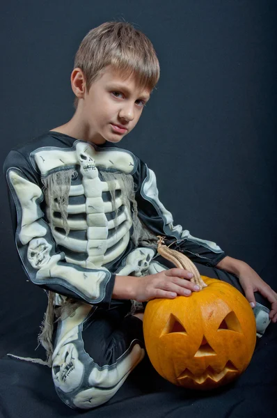 Boy in Halloween costume with orange pumpkin — Stock Photo, Image