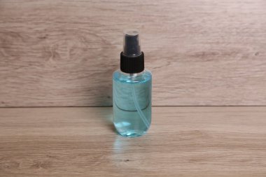 Mavi sıvıyla dolu küçük bir şişe tahta bir yüzey üzerinde dikilir. Tasarım temel ve net, şişenin içeriğini vurguluyor..