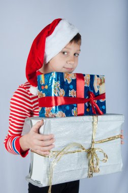 Noel Baba şapkalı kutuları tutarak şirin çocuk