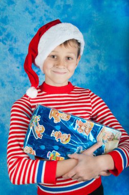 Noel Baba şapkası mavi kutu tutan mutlu çocuk